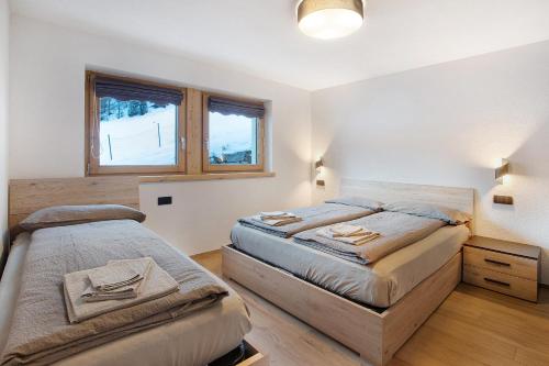 una camera con due letti e una finestra di Palipert Nature House a Livigno