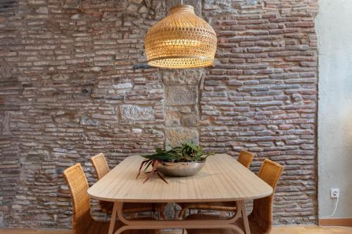 a wooden table with chairs and a potted plant on it at Flateli Cort Reial 7 in Girona