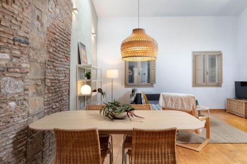 a dining room with a table and a brick wall at Flateli Cort Reial 7 in Girona