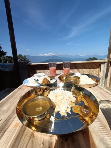 a wooden table with plates of food on it at Hamro Ghar Farmstay in Darjeeling