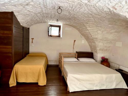 two beds in a room with a stone wall at La Pergola in Locorotondo