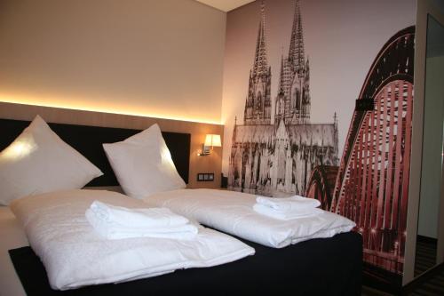 a bedroom with two beds with white towels on them at Hotel Fortune in Cologne