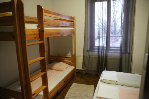 a bedroom with two bunk beds and a window at Déjá Vu Szállás & Rendezvény Zirc in Zirc