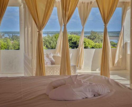 a bedroom with a bed with a large window at Kilele House in Shela