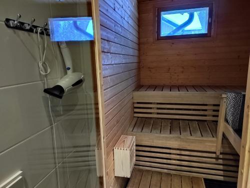 a sauna with a shower and a window at Villa IRIS 3, Himos in Jämsä