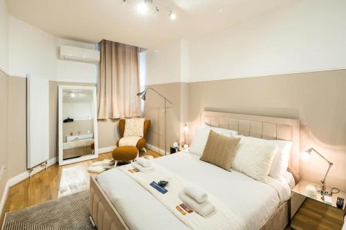Un dormitorio con una gran cama blanca y una silla. en Superb Flat in South Kensington, en Londres