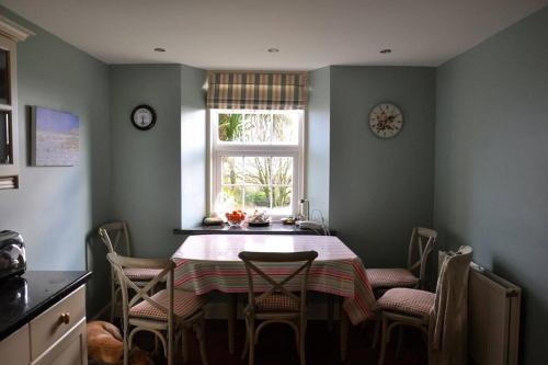 a kitchen with a table and chairs and a window at Beautiful spacious old schoolhouse with stunning sea views and beach nearby in Port Bannatyne