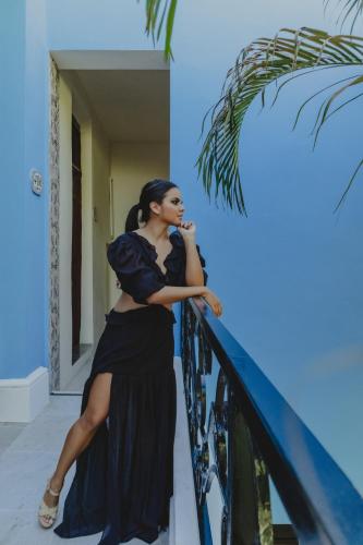 a woman in a black dress talking on a cell phone at Hotel del Gobernador in Mérida