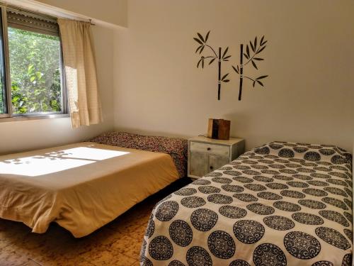 a bedroom with two beds and a window at Gaia Hostal in Tigre