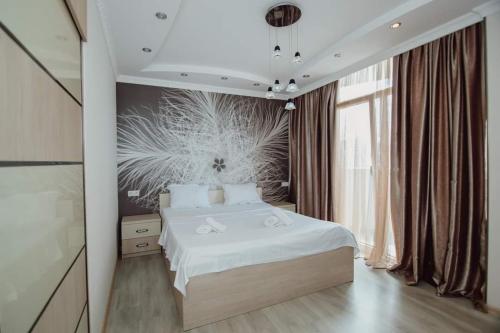 um quarto com uma cama branca e uma grande janela em Apartment Rimma em Batumi