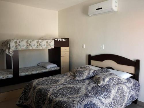 Dormitorio con cama, litera y cama en Casa com piscina / Na quadra do mar Torres-RS en Torres