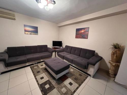 un soggiorno con 2 divani e un tavolo di Entire nice apartment, in the center a Tirana