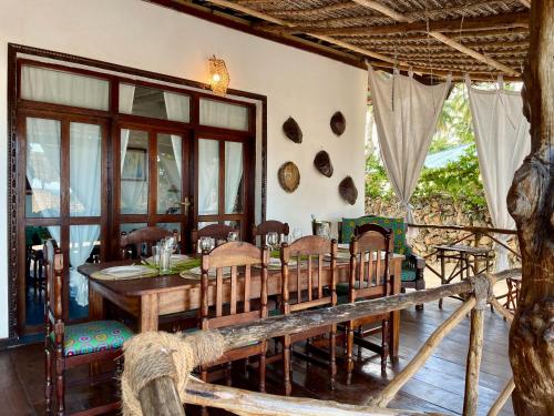 普瓦尼麥坎加尼的住宿－Villa Kipara - Beachfront with Private Pool，一间带木桌和椅子的用餐室