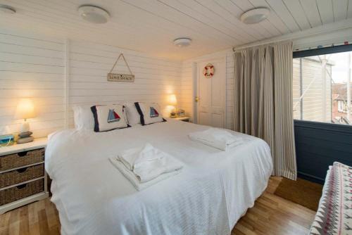 um quarto com uma grande cama branca e 2 almofadas em Flat 1, Baymount em Seaview