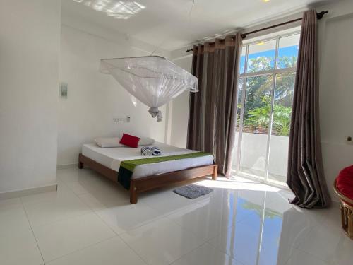 a bedroom with a bed and an umbrella in it at Manjari Villas Madiha in Matara