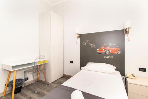 1 dormitorio con 1 cama con coche en la pared en Hotel Cristallo Torino en Turín