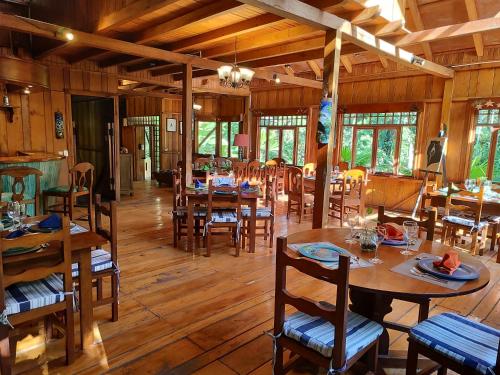 comedor con mesas y sillas de madera en Mindo Garden Lodge and Wildlife Reserve, en Mindo