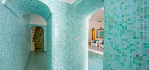 une chambre avec des murs carrelés bleus et une chambre avec un canapé dans l'établissement Villa Il Canto - Homelike Villas, à Positano