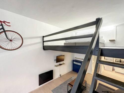 un lit en mezzanine avec un vélo suspendu au mur dans l'établissement La Suite Duhamel - Au pied de la Gare - Au Calme, à Rennes