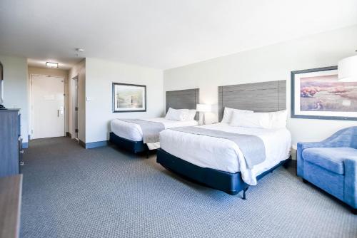 a hotel room with two beds and a blue couch at Shutters Hotel in Elko