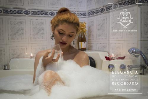 una mujer sentada en una bañera llena de espuma en HOTEL MADURAI, en Ambato