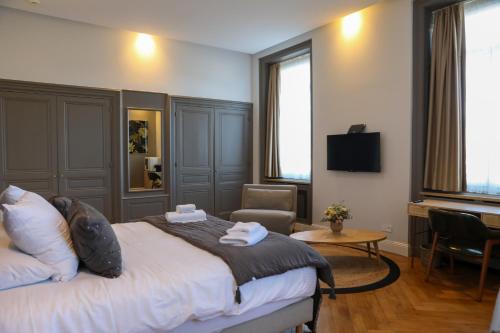 a hotel room with a bed and a chair at Séquoias Golf & Ressort in Ruy