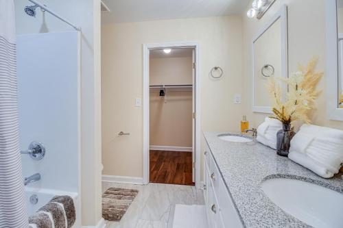 - Baño blanco con 2 lavabos y ducha en Family Home Near Downtown and Convention Center! en Savannah