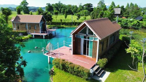 a cabin on a lake with a dock at BaanSuan Marigold บ้านสวนมาลีโกลด์ in Ban Madua Chumphon