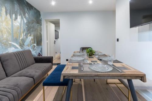 une salle à manger avec une table et un canapé dans l'établissement Au pied du Sacré coeur - 5 pers, à Paris