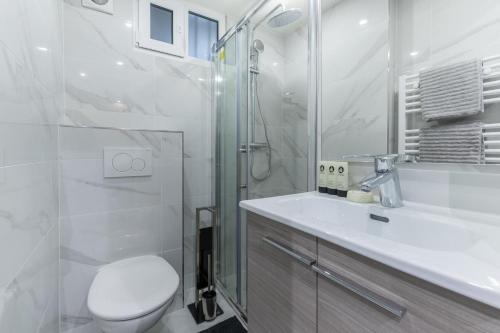 une salle de bain avec toilettes, douche et lavabo dans l'établissement Au pied du Sacré coeur - 5 pers, à Paris