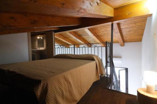 a bed in a room with a wooden ceiling at Le case del Carmine con giardino e parcheggio a Tropea in Tropea