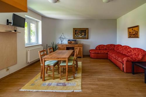 a living room with a table and a red couch at Apartmány Gulliver in Mikulov