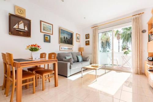 sala de estar con mesa y sofá en Sitges Seafront Ribera Apartment, en Sitges