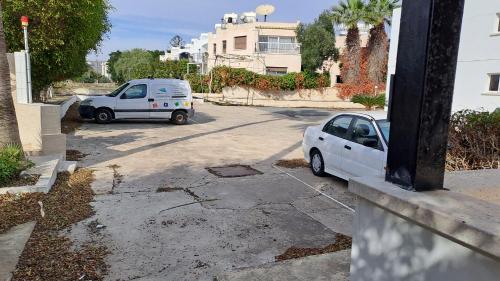 a white car is parked in a parking lot at 30meters from the sea apartment in Larnaca in Voroklini