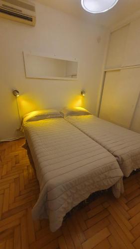 1 dormitorio con 2 camas y una luz en la pared en Universidad Maimonides Apartamento 2 amb en Buenos Aires
