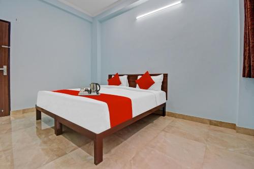 Flagship Hotel Ansh Plaza في جايبور: غرفة نوم بسرير كبير ومخدات حمراء