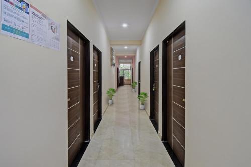 a hallway with brown doors and potted plants at Flagship Hotel Ansh Plaza in Jaipur
