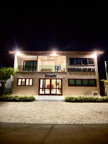 a white building with a sign on it at night at Pousada Litoral Paraty in Paraty