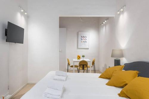 een slaapkamer met een wit bed met gele kussens en een tafel bij UNYCA - Art of Florence Apartment in Florence