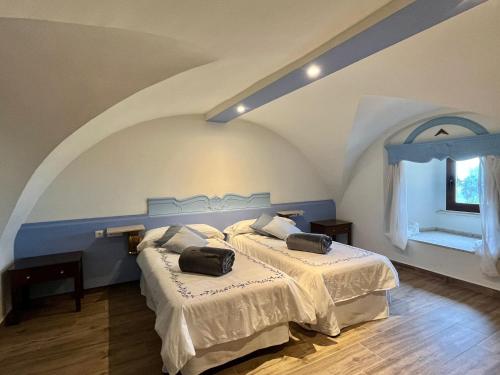 een slaapkamer met 2 bedden en een raam bij Casa Palacio El Trasquilon in Cáceres