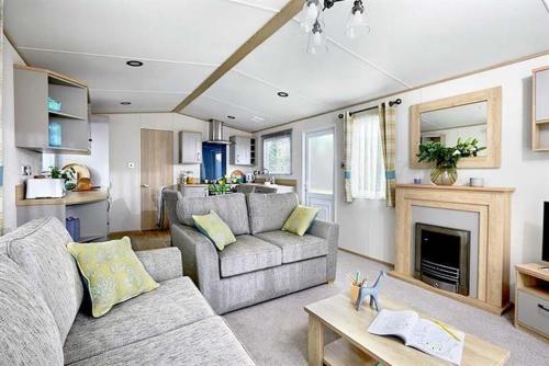 a living room with a couch and a fireplace at Cornwall Holiday Cabin with Hot tub & Sea view in Cubert