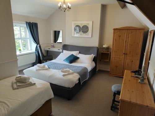 1 dormitorio con 2 camas, mesa y escritorio en Kings Arms Hotel, en Kirkby Lonsdale