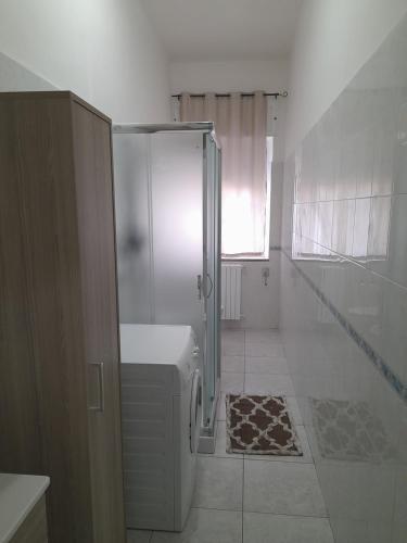 a white bathroom with a shower and a toilet at Casa Brezza marina in Barletta