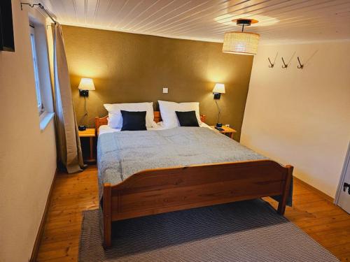 a bedroom with a large bed with two lamps and two tables at Friends&Family Veldenz L in Veldenz
