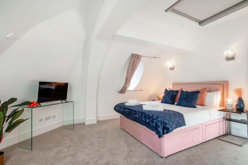 a bedroom with a large bed and a tv at Welcome London - Trafalgar Square in London