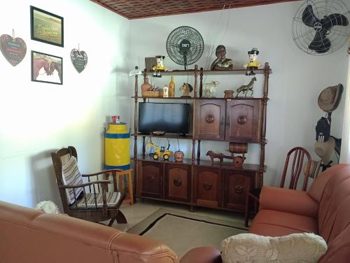 uma sala de estar com um sofá e uma televisão em CHÁCARA TERRA dos SONHOS em Guaratinguetá