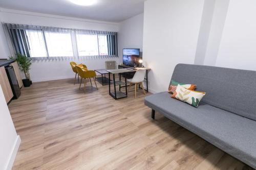 ein Wohnzimmer mit einem Sofa und einem Tisch in der Unterkunft Estudio-oficina moderno, centro de Jaén in Jaén
