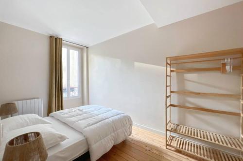 ein weißes Schlafzimmer mit einem Bett und einem Fenster in der Unterkunft Mytripinparis - Fully renovated 2 bedrooms in Neuilly-sur-Seine