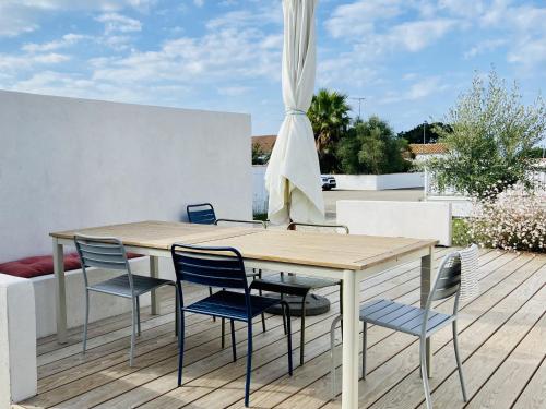une table et des chaises en bois sur une terrasse dans l'établissement Maison moderne pour 5 personnes à Noirmoutier, à Noirmoutier-en-l'lle