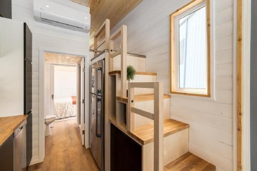 a tiny house with a staircase and a window at Mini Muskoka Getaway - Huntsville in Huntsville